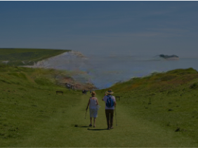 a couple walks towards ocean